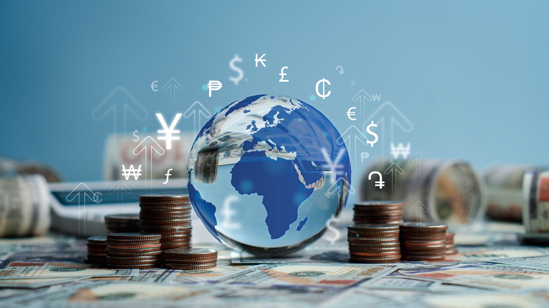 Crystal globe with symbols of international currencies including dollar, yen, yuan, euro, pound sterling, ruble and rupee placed on banknotes and stack of coins. World Bank ,Economic Inflation